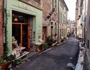 : Par beau temps les étals des bouquinistes annoncés par de jolies enseignes envahissent les venelles du village.